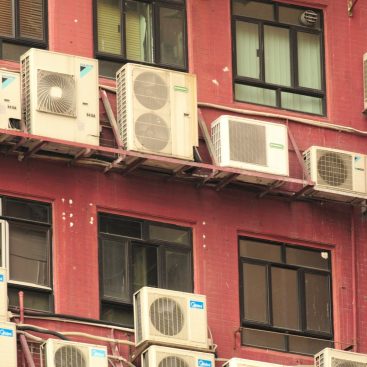 Air conditioning condensers mounted across an apartment building facade