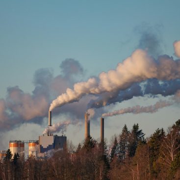 Steam and flue gas rising from the stacks of an industrial plant