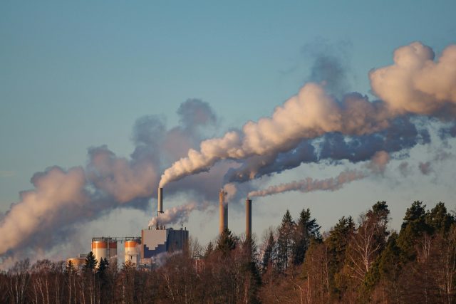 Steam and flue gas rising from the stacks of an industrial plant